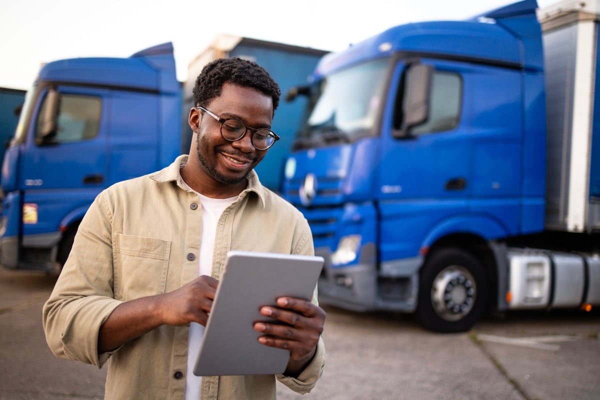 Truck driver holding digital tablet and preparing for the ride.